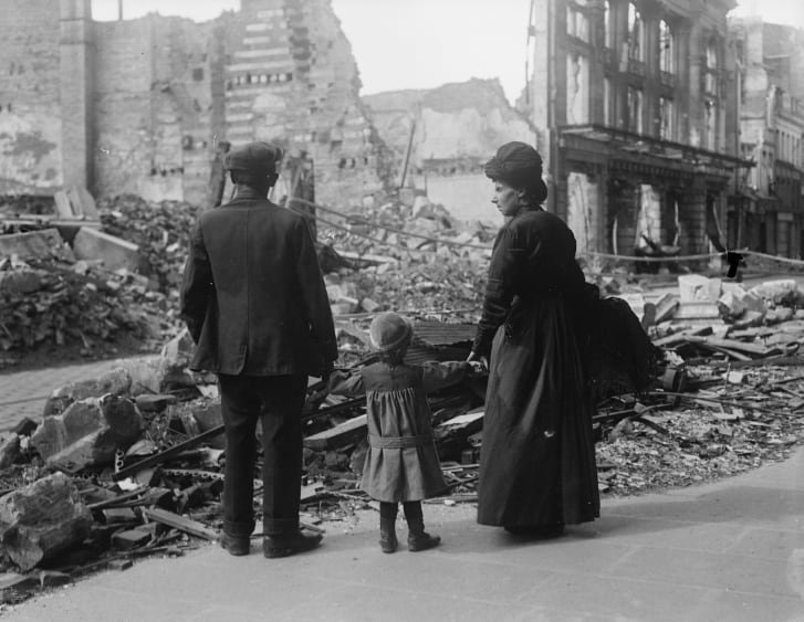 A refugee family returning to Amiens, France, looking at the ruins of a house on Sept. 17, 1918. Photo Credit: IWM (edition.cnn.com)