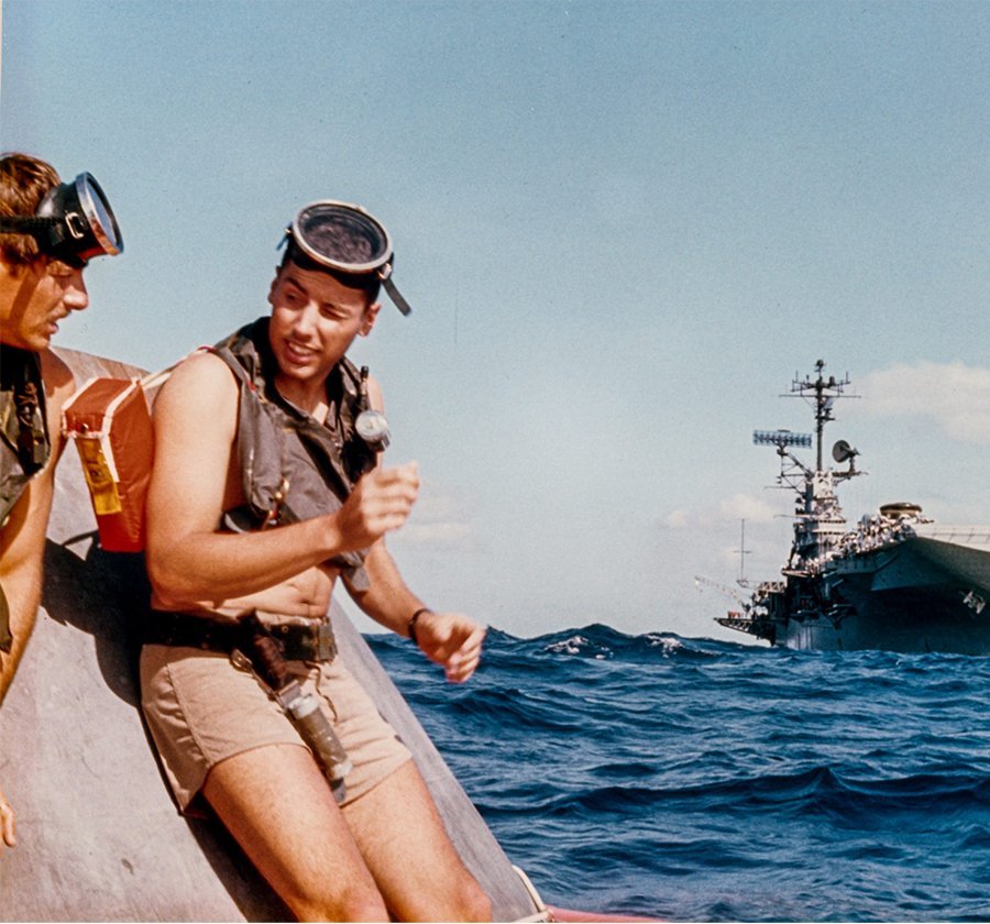 Swimmers on the Apollo 11 Command Module and at the back is USS Hornet. Photo Credit: Naval Helicopter Association Historical Society